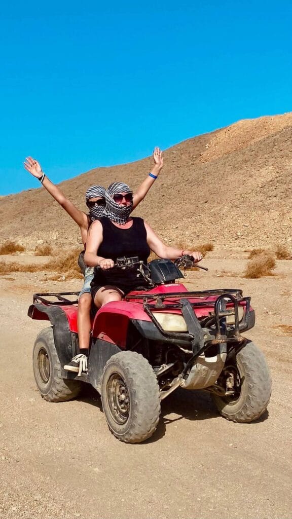 Ein Paar bei einer actiongeladenen Quad-Tour in der Wüste von Sharm El Sheikh – ein Highlight der besten Reisezeit für Ägypten Ausflüge im Sommer.