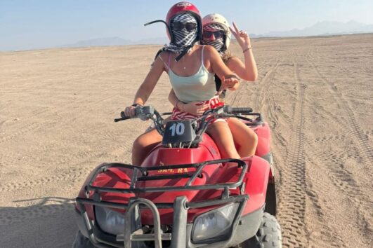 Ägypten Quad fahren – Zwei Touristinnen auf einem privaten Quad-Ausflug in der Wüste von Hurghada, Makadi Bay. Abenteuer, Wüstensand und Action pur.
