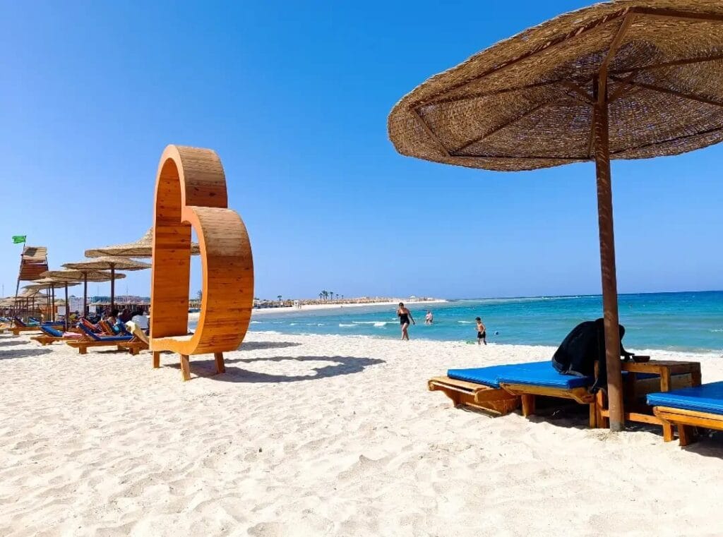 Touristen verlassen nach dem Schnorcheln das kristallklare Wasser am Strand der Abu Dabbab Bucht Marsa Alam.
