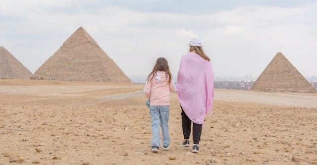 Urlaub mit Kindern in Ägypten – Die besten Hotels, Tipps und Ausflüge für Familien 5 Zwei Kinder bei den Pyramiden von Gizeh.Sie genießen ihren Familienurlab in Ägypten