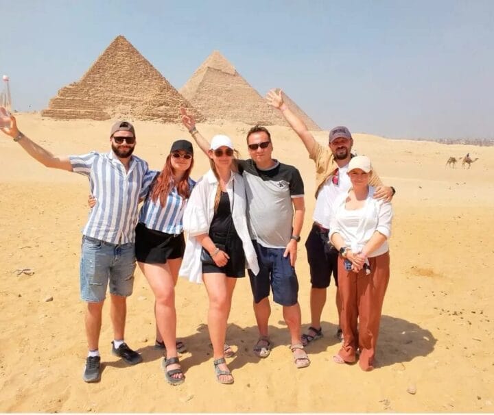 Eine glückliche Familie vor den drei Pyramiden von Gizeh bei dem Zwei Tagesausflug von Hurghada nach Kairo mit dem Flug.