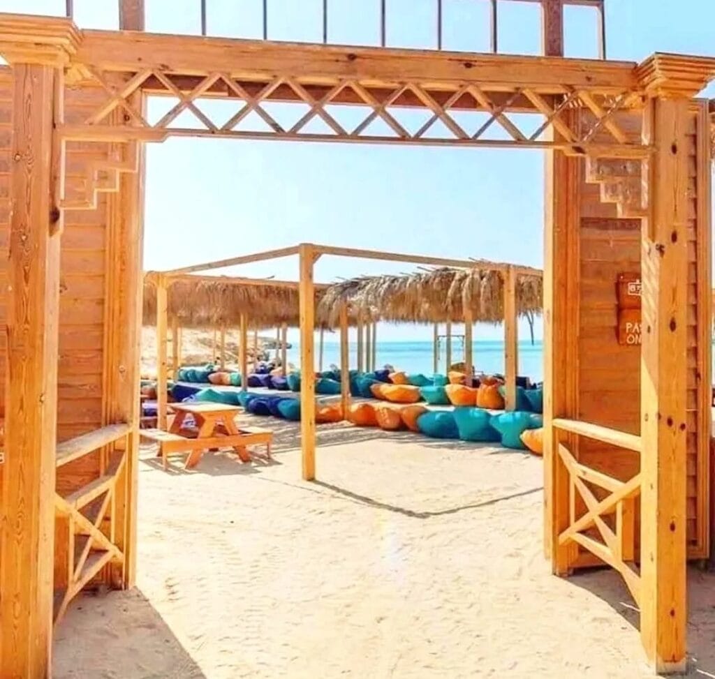 Komfortable Sonnenliegen am weißen Sandstrand von Orange Bay Hurghada mit Blick auf das türkisfarbene Rote Meer – der perfekte Ort zum Entspannen während eines Tagesausflugs auf die Giftun Island.
