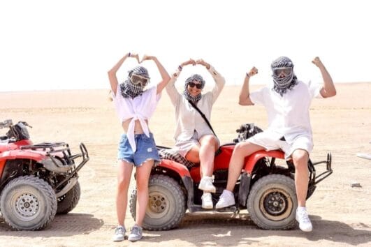 Zufriedene Gäste bei einer entspannten Pause während der Marsa Alam Quad Tour Sonnenaufgang in der Wüste