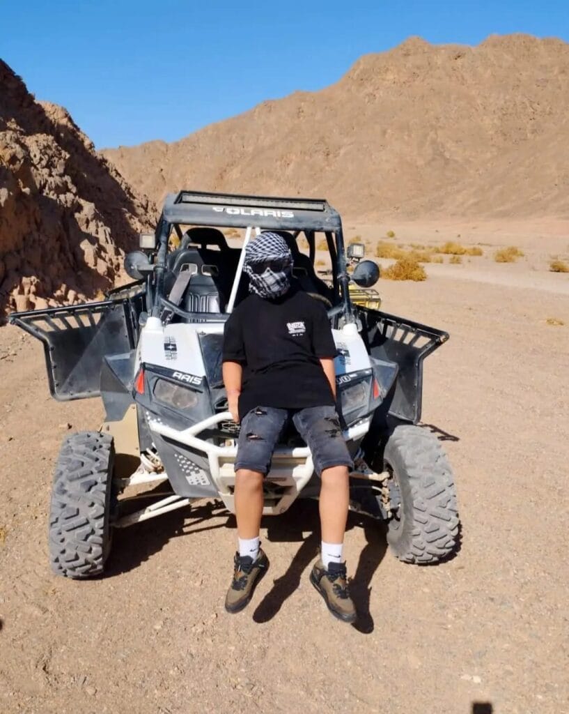 Ein Kind steht neben seinem Sandbuggy in Marsa Alam und wartet auf die Tour