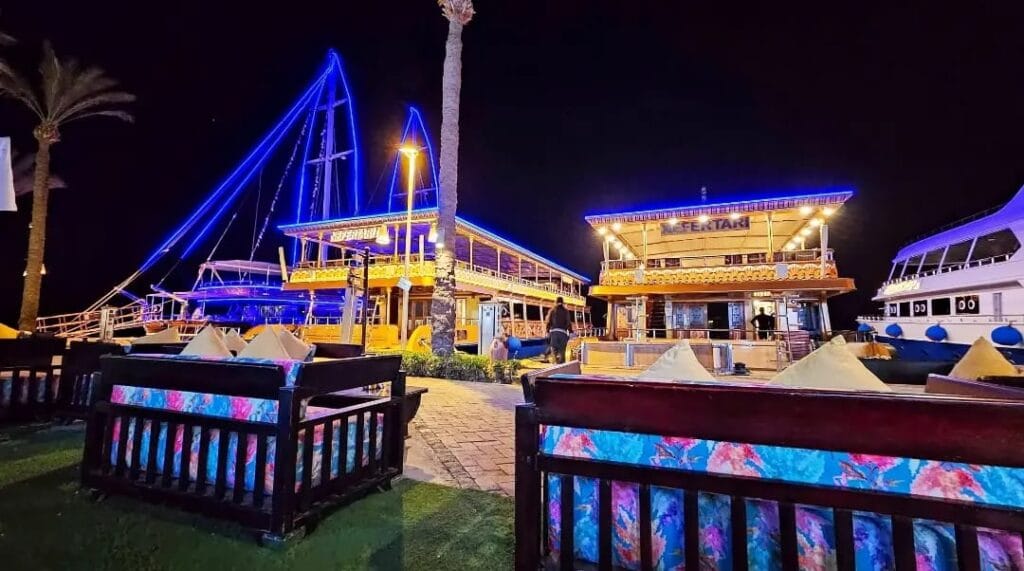 Was kann man in Port Ghalib machen? Dein Insider-Guide für einen unvergesslichen Urlaub 5 Port Ghalib Sehenswürdigkeiten – Die Marina von Port Ghalib bei Nacht mit beleuchteten Yachten, Restaurants und Cafés.