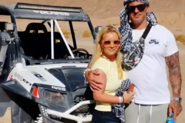 Urlauberpaar bei einer Buggy Tour ab Makadi Bay neben einem Geländebuggy in der ägyptischen Wüste.