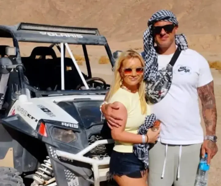 Urlauberpaar bei einer Buggy Tour ab Makadi Bay neben einem Geländebuggy in der ägyptischen Wüste.