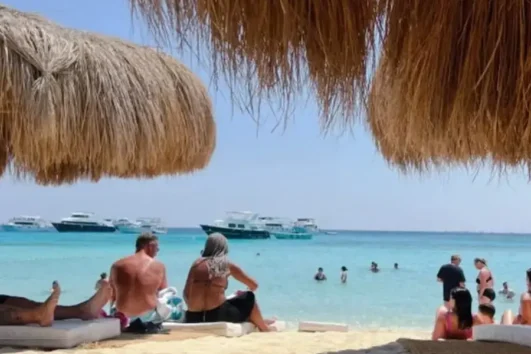 Hula Hula Insel ab Makadi Bay mit weißem Sandstrand, türkisblauem Meer und Urlaubern.
