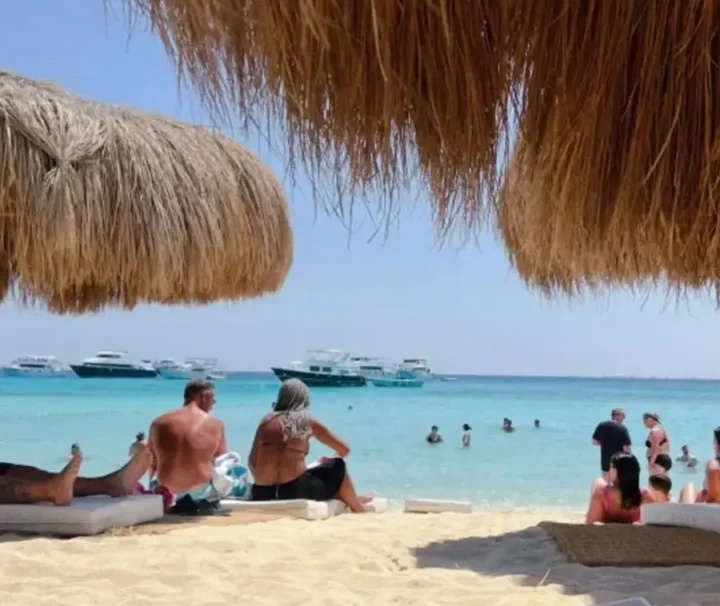 Hula Hula Insel ab Makadi Bay mit weißem Sandstrand, türkisblauem Meer und Urlaubern.